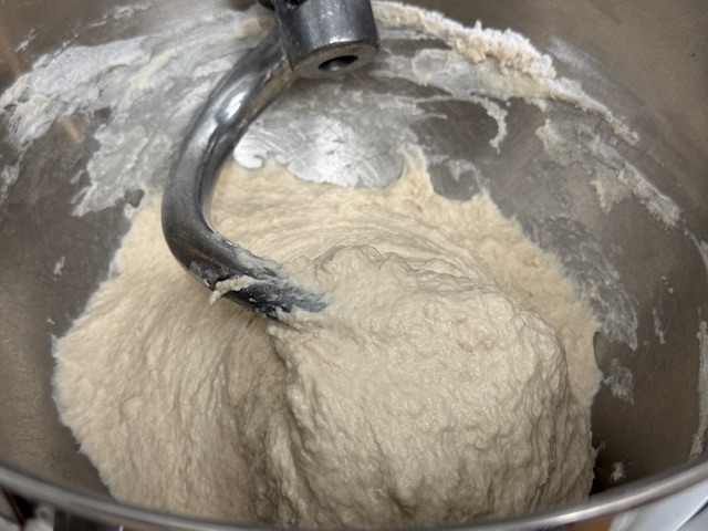 Pâte dans le bol d'un robot, collée au crochet