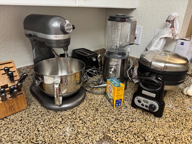 Comptoir à droite du four -- il y a un robot pâtissier, un mixeur, un gaufrier et un grille-pain.