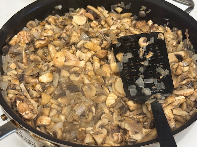 Le reste des champignons ajouté à la poêle de champignons et d'échalotes