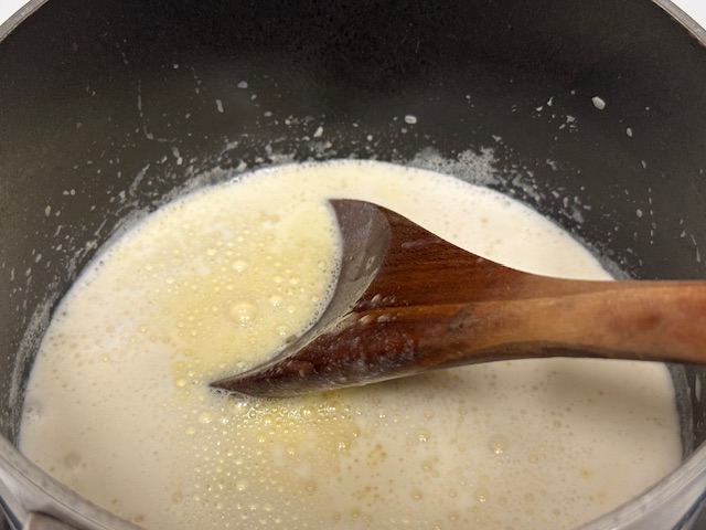 Lait versé dans la casserole avec le mélange d'œufs