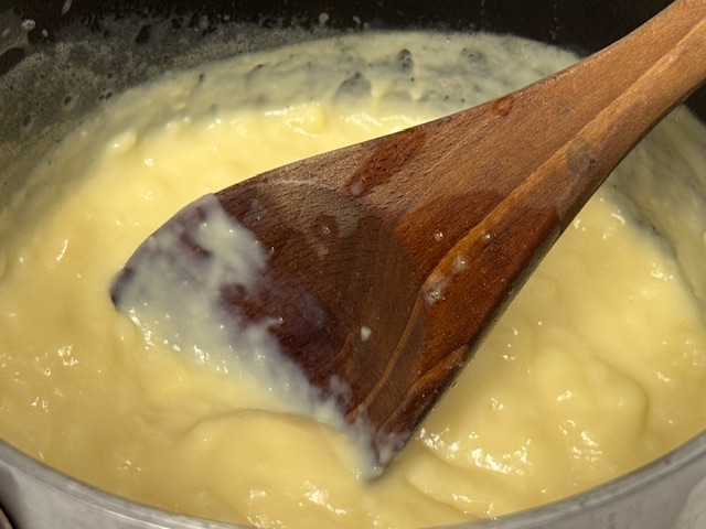 Crème pâtissière dans la casserole, bien épaisse, avec une cuillère en bois au centre