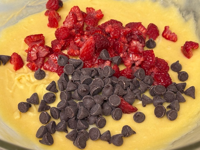 Morceaux de framboise et pépites de chocolat versés sur la pâte 