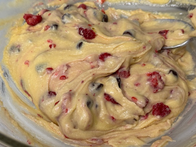 Pâte bien mélangée avec des morceaux de framboise et des pépites de chocolat visibles partout