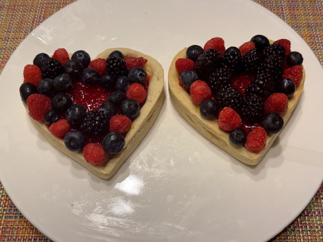Deux cœurs bien garnis de fruits, avec un petit cercle de confiture visible au centre de chacun. Les fruits alternent pour un effet un peu damier, mais suivant la forme du cœur.