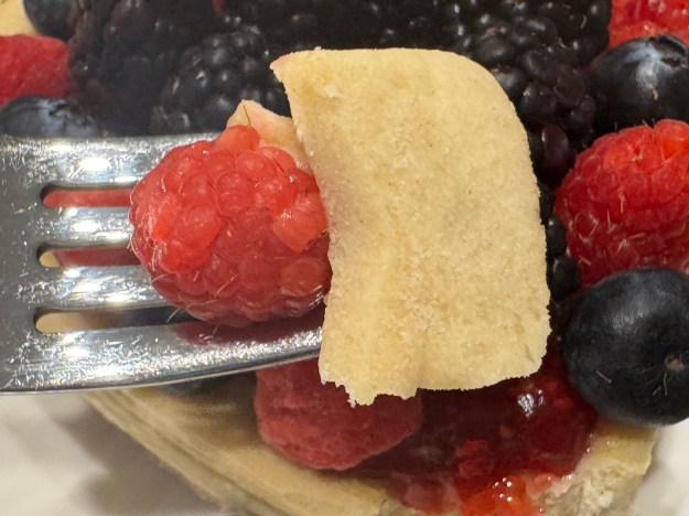 Le point vers le bas brisé et sur une fourchette avec une seule framboise