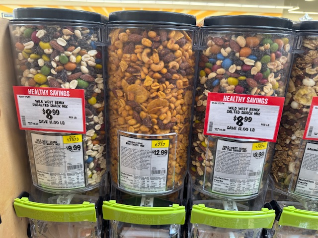 Ce sont des conteneurs grands et étroits, avec des produits en vrac. On tire sur un levier pour les faire verser dans un sac en plastique que l'on tient au-dessous.