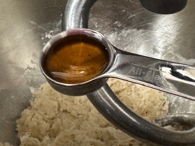 Cuillère de café de miel en gros plan, posée sur le bol