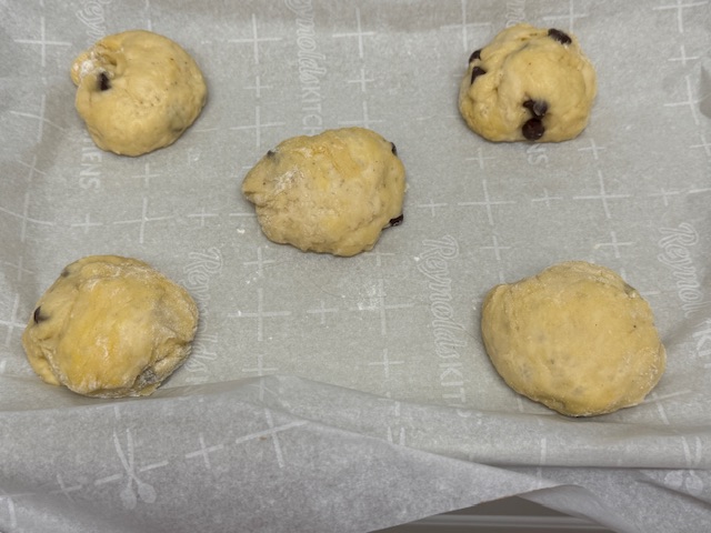 Boules gonflées après 2 heures pour pousser, sur du papier de cuisson
