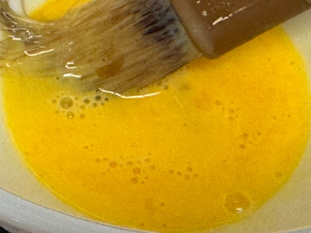 Mélange de lait et jaune d'œuf ; le pinceau est visible vers le fond