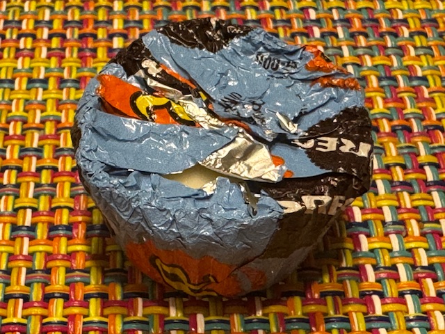 Un bonbon dans son emballage bleu et orange (les couleurs des deux marques)