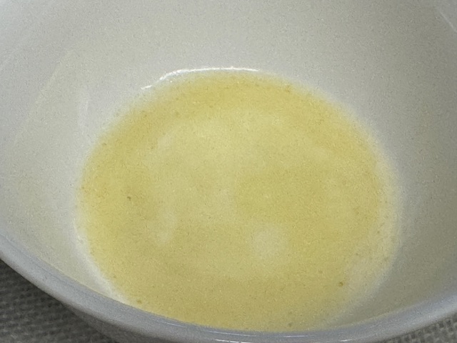 Beurre fondu dans un petit bol blanc.