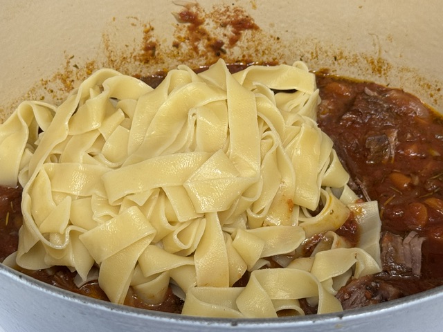 Pâtes versées dans la cocotte ; elles flottent sur la sauce
