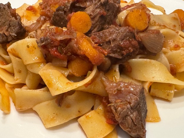 Vue des pâtes en gros plan pour mieux voir la viande et les morceaux de carottes