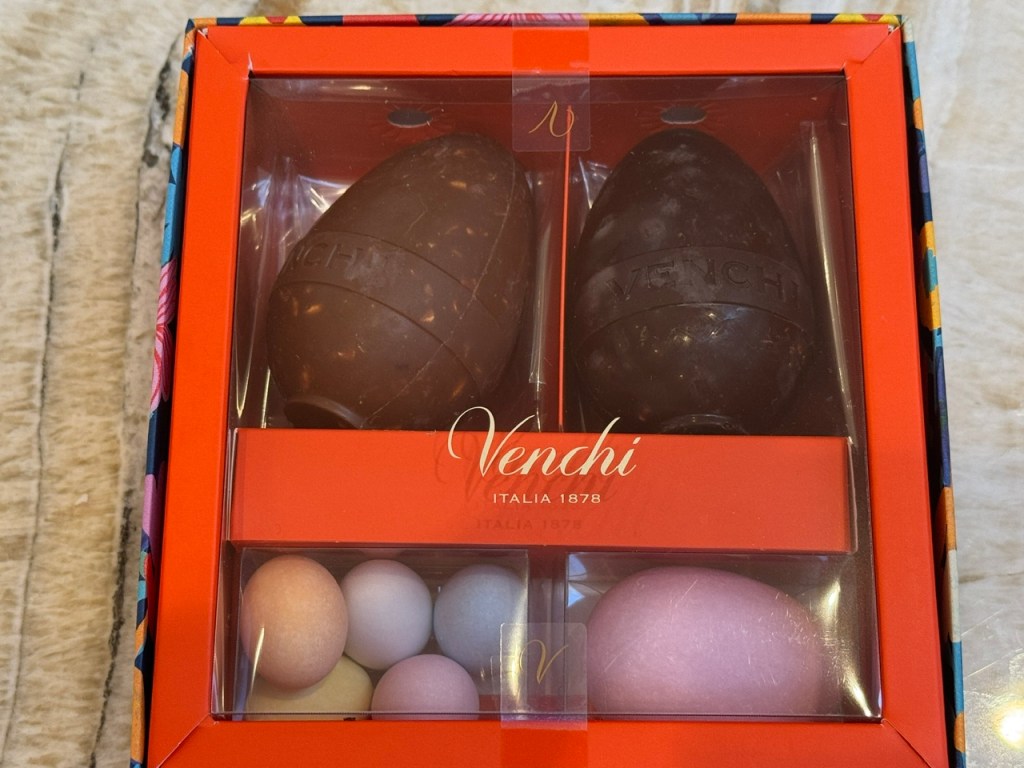 Boîte qui contient deux gros œufs en chocolat, une poignée de dragées, et un autre truc en forme d'œuf où je ne sais pas ce qu'il est.