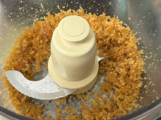 De petits morceaux de caramel solide dans le bol d'un robot pâtissier