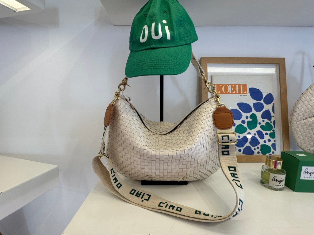 Sac à main en cuir blanc tissé. La bandoulière est en tissu imprimé avec le mot Ciao encore et encore