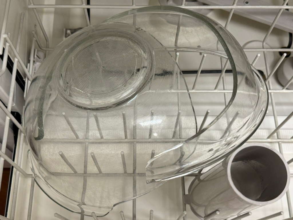 Saladier sens dessus-dessous dans le lave-vaisselle. C'est brisé en deux au long d'une fissure au sens de la largeur.