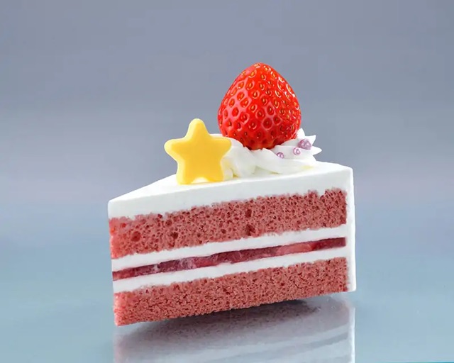 Gâteau comme un fraisier : deux couches de génoise roses, séparées par très couches très fines, deux d'une sorte de crème autour d'une autre qui semble être une confiture. Il y a plus de la crème en haut et aux côtés, avec une fraise entière, posée dessus-dessous au-dessous, avec une petite étoile jaune, probablement en pâte de sucre.