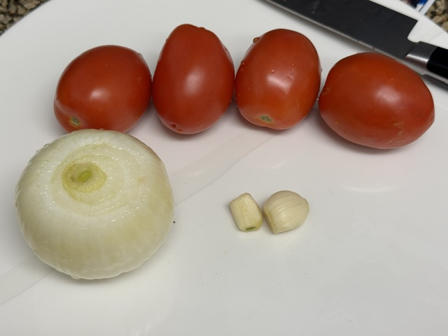 Tomates, oignon et 2 gousses d'ail sur une assiette