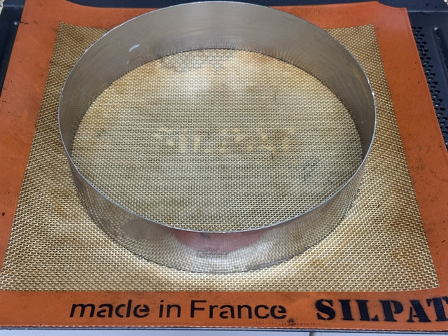 Cercle à pâtisserie sur la plaque et tapis
