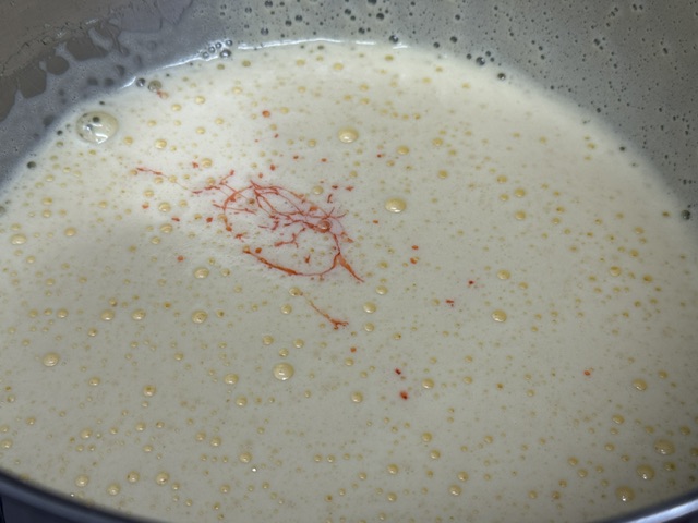 Traces de sirop de fraise visible sur la surface du mélange, qui reste blanc