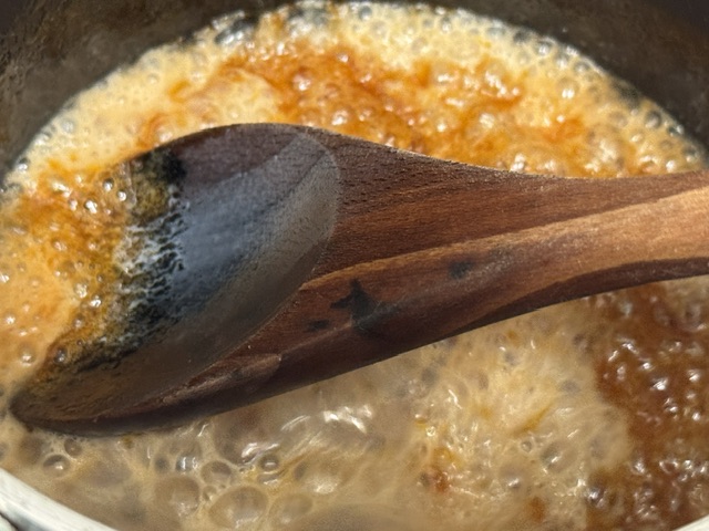 Du caramel bien bouillant, juste après avoir versé la crème dans le bol -- le choc thermique provoque des bulles vives