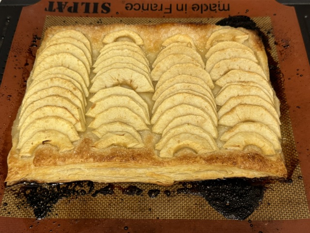 Tarte sur la plaque de cuisson -- il y a des trucs noirs sur le tapis en silicone où du sucre a brûlé. Ça ne viendra pas avec la tarte une fois retirée.