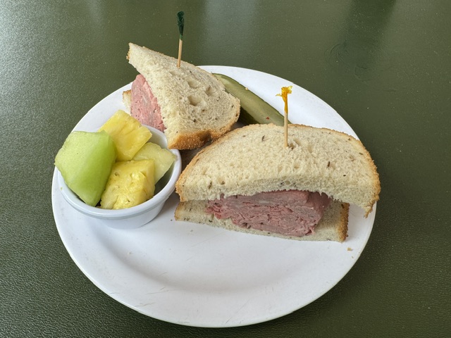 Sandwich de bœuf rôti avec du pain de seigle et un petit bol de fruits
