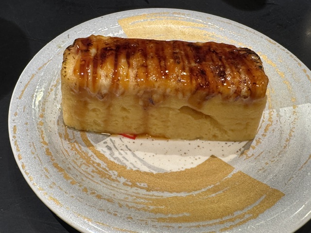 Rectangle de tamago, l'omelette japonaise, recouverte avec de la sauce soja 