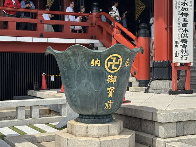 Une sorte de baignoire en pierre noire, avec des kanjis dorés