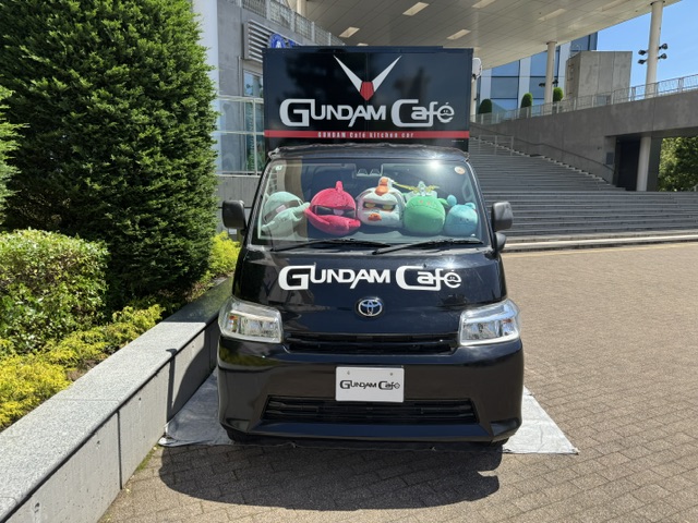 Pare-brise du camion -- trois poupées « tête de Gundam » et deux petits extra-terrestres comme le dos du camion