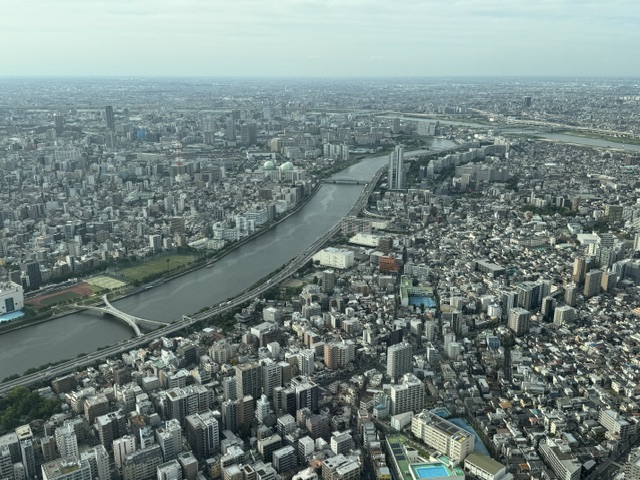Long fleuve qui atteint la Baie de Tokyo, entouré par des bâtiments partout