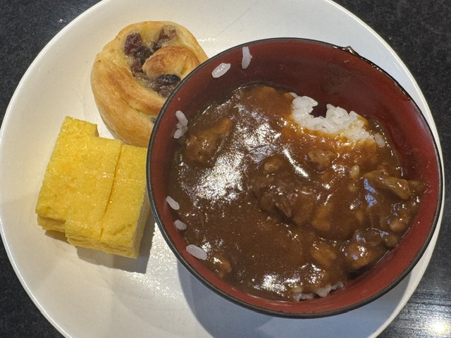 Assiette avec un pain aux raisins, du curry, et des morceaux de tamago 