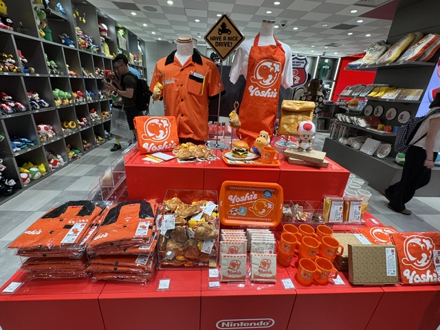 Table plein de tabliers, d'aimants, de tasses et de chemises, largement colorés rouge