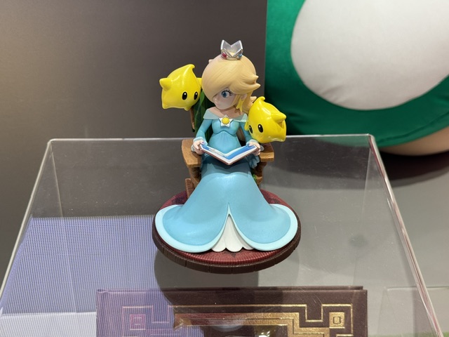 Petite figurine de la princesse Harmonie, assise pour lire à deux Lumas