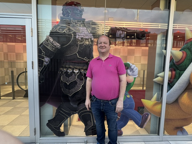 C'est Justin, avec un polo violet, devant un dessin de Ganondorf