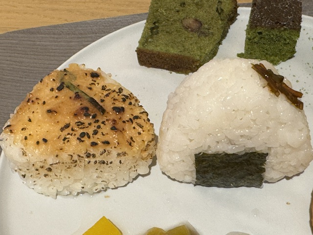 Deux onigiris kujo miso -- un triangle de riz à moitié emballé dans de l'algue, et un triangle de riz avec un haut marron, car assaisonné de miso
