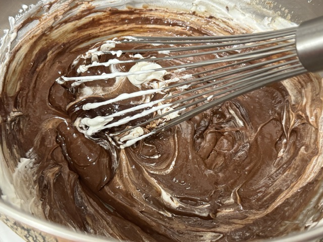 Je mélange la chantilly avec les œufs et le chocolat -- ça aide à rendre lisse le mélange coincé dans le fouet