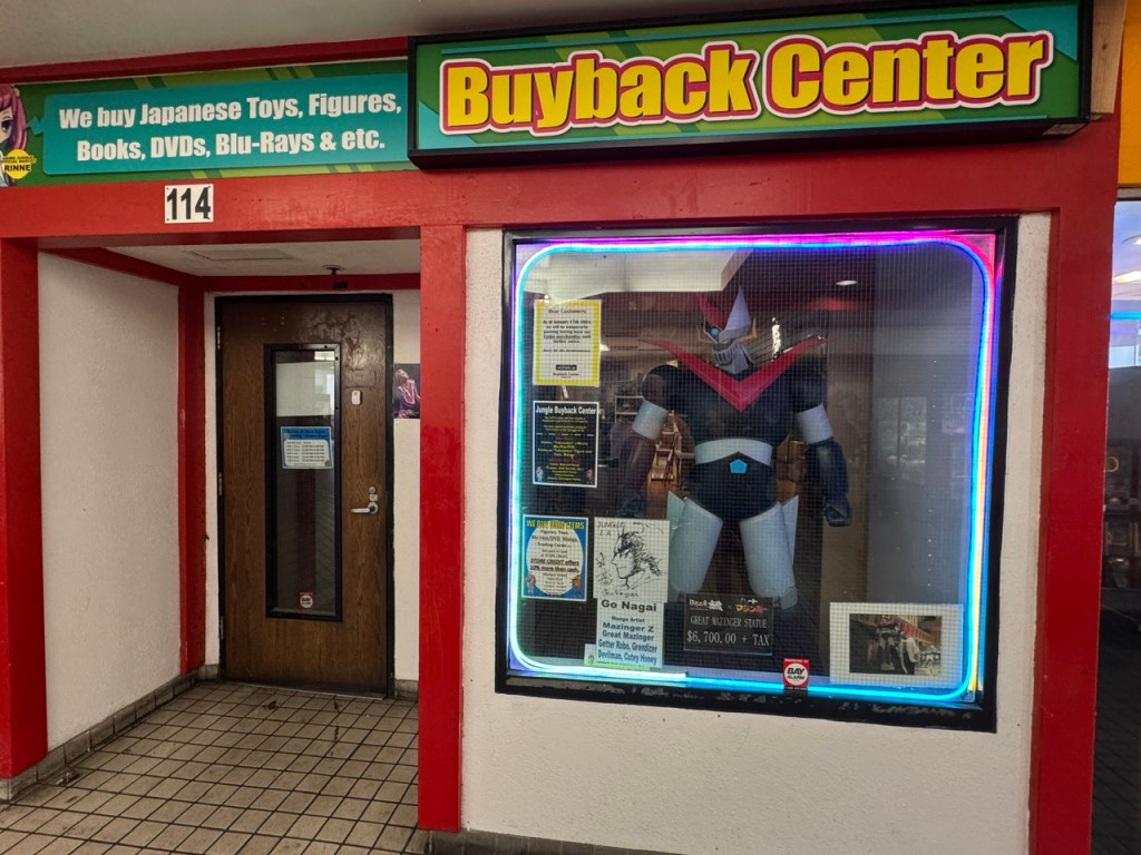 Vitrine de la boutique Buyback Center avec une statue du robot Mazinger