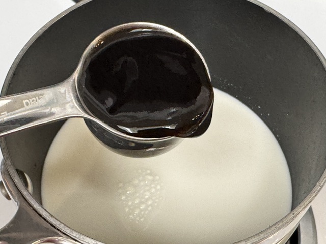 Cuillère à soupe de pâte de vanille posée sur le lait
