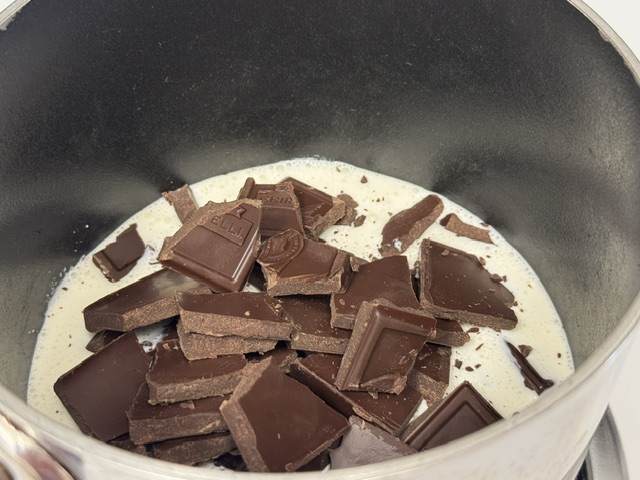 Morceaux de chocolat noir flottant sur la crème