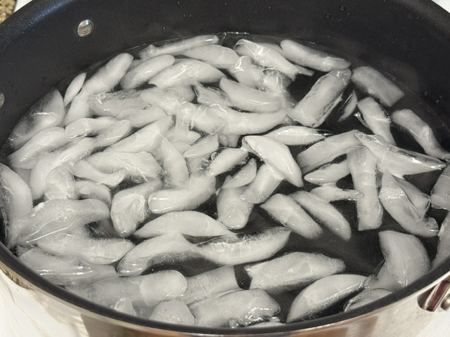 Casserole géante avec des glaçons flottant dans l'eau
