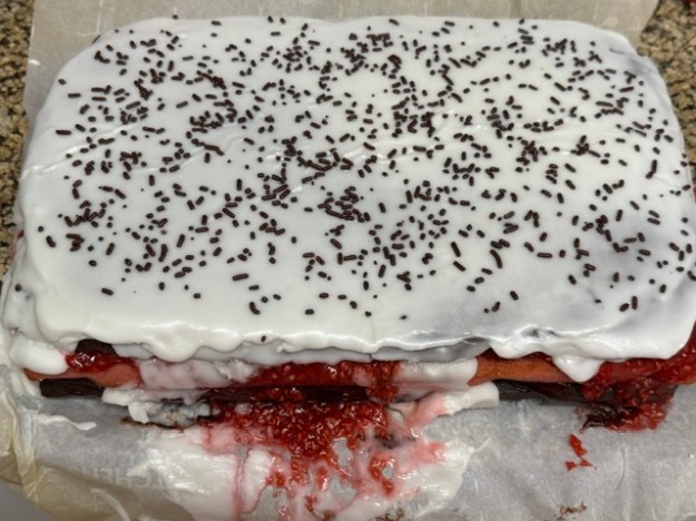Gâteau parsemé de vermicelles. La vue est d'en haut, mais il y a de la confiture coulant sur les bords partout, ainsi qu'un peu de fondant.