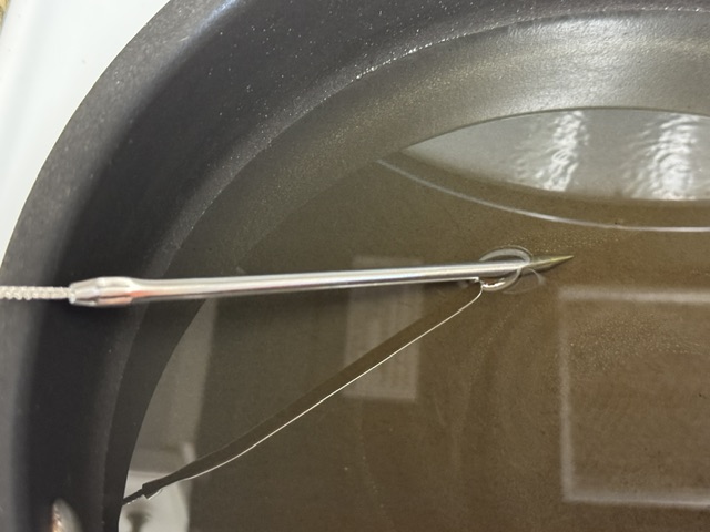 Poêle avec de l'huile. La sonde du thermomètre est visible à gauche.