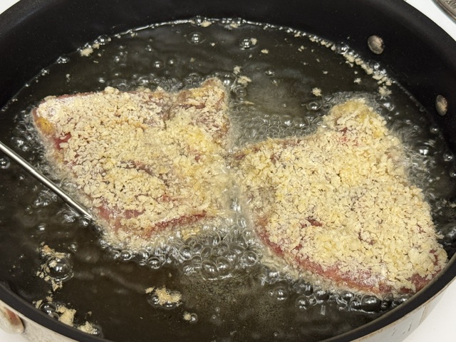 Deux steaks dans l'huile au début de la cuisson