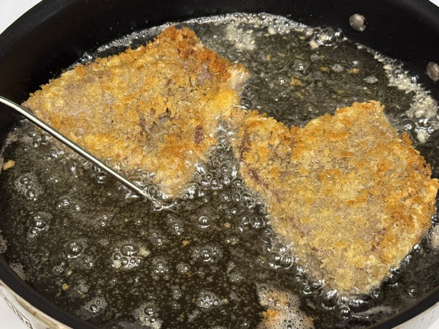 Steaks vers la fin de la cuisson -- l'huile bout vigoureusement et le panko est plus marron foncé 