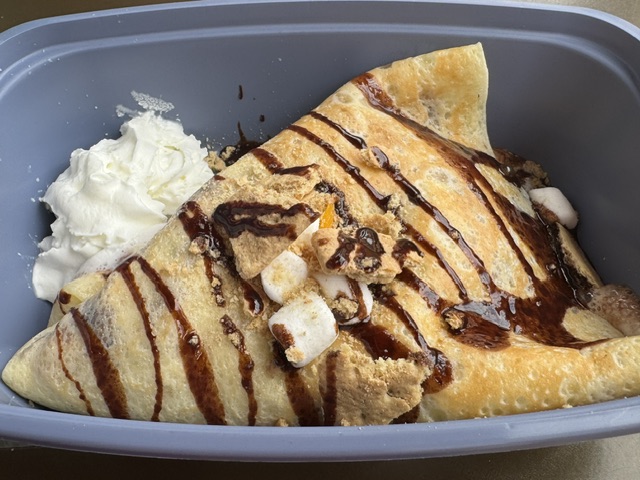 C'est une crêpe avec quelques petites guimauves posées au-dessus, avec de la sauce au chocolat
