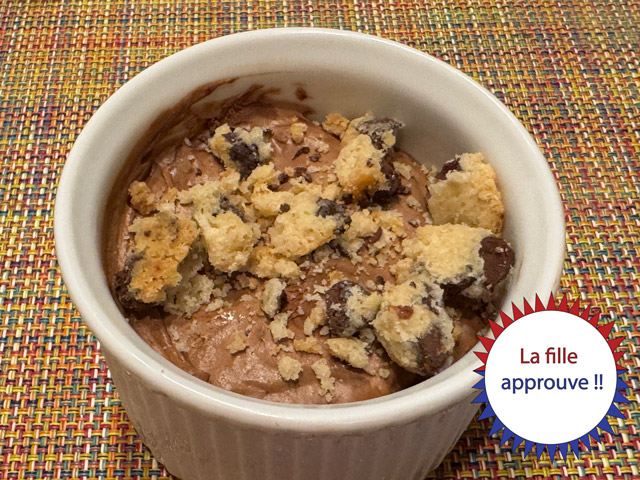 Ramequin de mousse avec des éclats de cookies. En bas à droite, il y a un badge en rouge et bleu qui dit « La Fille approuve ! ».