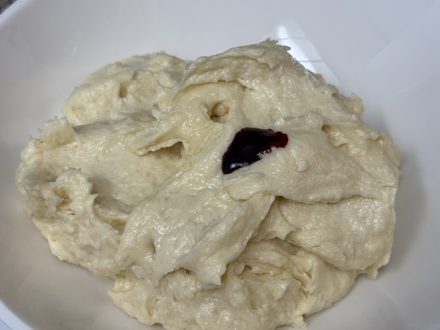 Pâte avec des gouttes de colorant rouge versées en haut