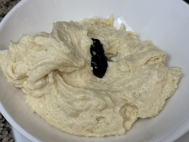 Pâte avec des gouttes de colorant vert versées en haut